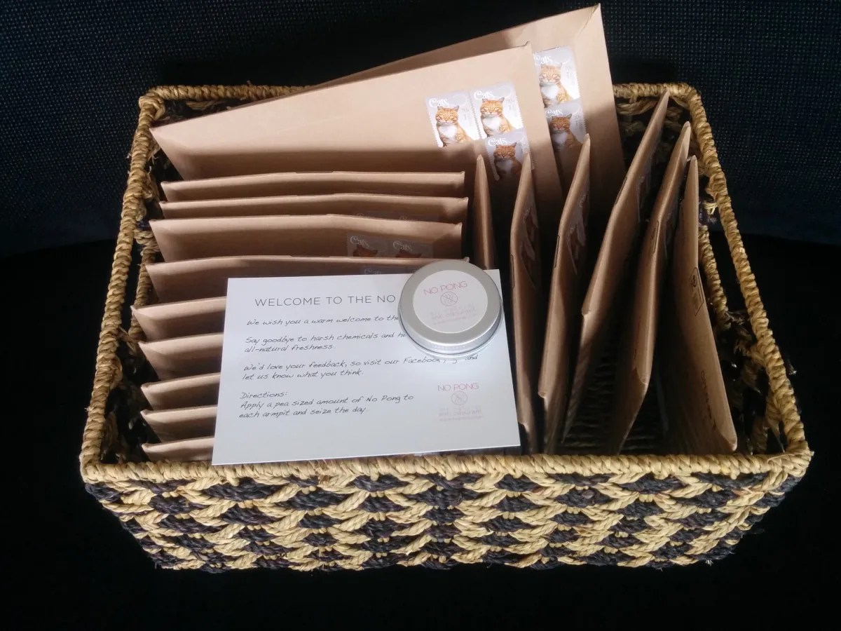 An early No Pong tin on the Welcome to the No Pong Club card, in a basket of envelopes ready to post, 2015