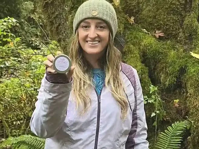 A No Pong customer on a forest trail holding up her tin