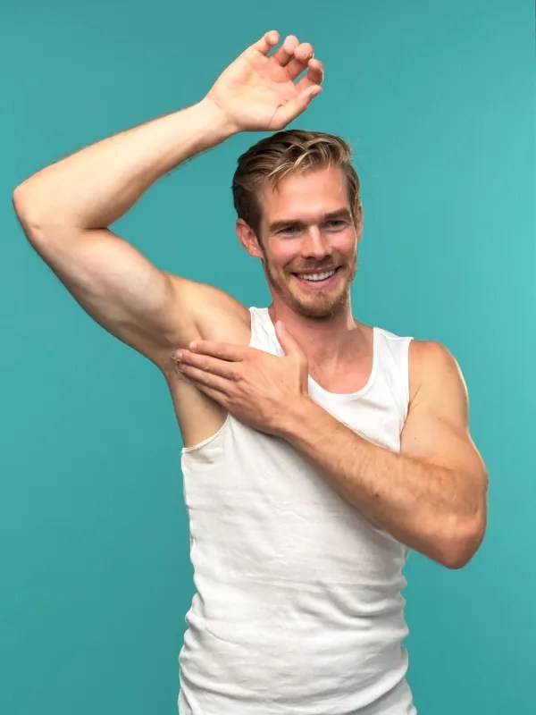 A No Pong customer in a white singlet raising his arm to apply No Pong, on teal